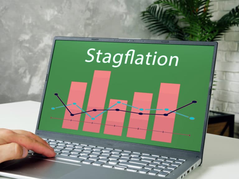A computer screen displays various financial graphs under the word “Stagflation.”