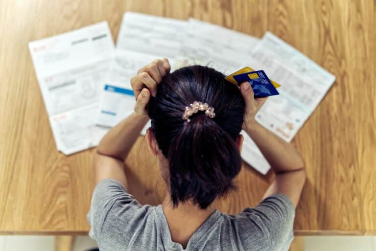 Asian woman hands holding the head worry about find money to pay credit card debt.