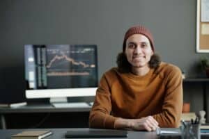 Young smiling male broker in casualwear looking at camera