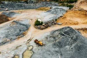 aerial view of truck excavator in open sand quarry rubble in fin