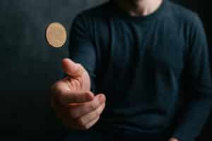 person tosses coin in moment of contemplation reflecting on great choices during times of depression